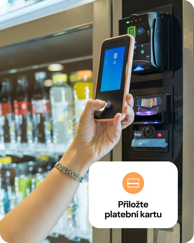 Zákazník platí mobilem u platebního terminálu na prodejním automatu s nápoji.