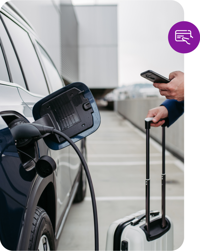 Zákazník čeká u nabíječky elektromobilu zatímco platí přes telefon.