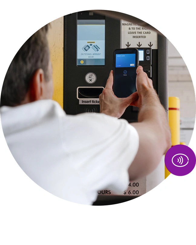 Zákazník platí mobilem u automatu na parkovací lístky.