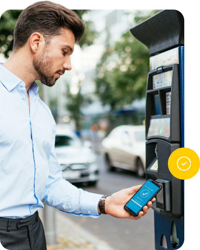 Zákazník platí parkovné mobilem u parkovacího automatu.