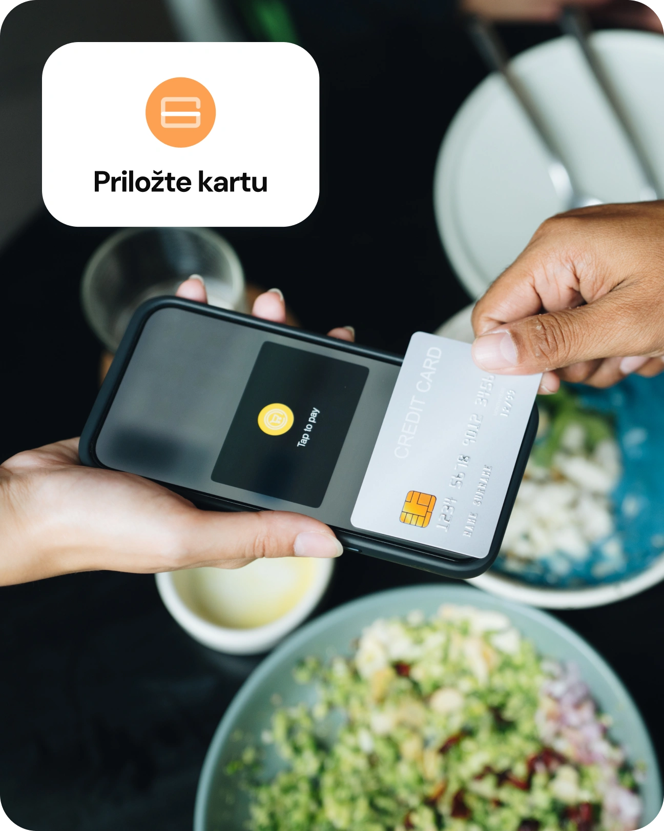 Zákazník přikládá platební kartu k terminálu při placení v restauraci.