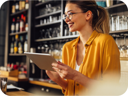 Usmívající se podnikatel drží tablet v restauraci.